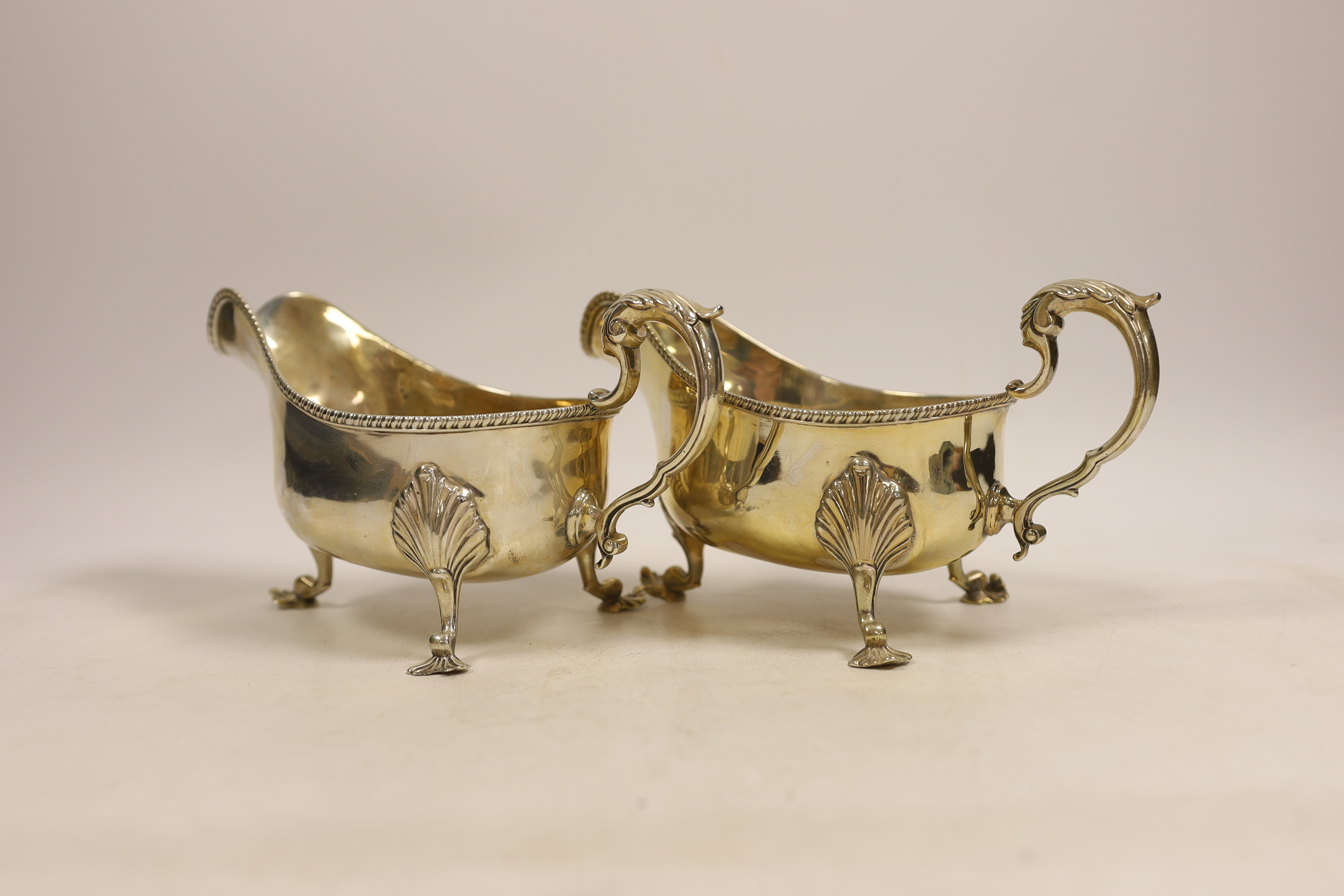 A pair of late Victorian silver sauceboats with gadrooned edge, double scroll handles on three shell and scroll feet, Wakely & Wheeler, London 1895, 21.3oz.